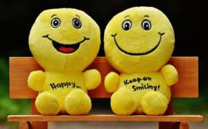 Bild mit 2 lachenden Smilies auf einer Bank.
